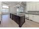 Kitchen with a dark island, stainless steel appliances, granite countertops, white cabinets, and a beverage cooler at 333 Sunrise Dr, Nokomis, FL 34275