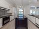 Spacious kitchen featuring an island with granite countertops, modern appliances, and pendant lighting at 333 Sunrise Dr, Nokomis, FL 34275