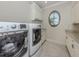 Bright laundry room featuring modern washer and dryer, granite countertops and custom cabinets at 333 Sunrise Dr, Nokomis, FL 34275