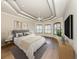 Main bedroom with tray ceiling, plantation shutters, wood floors, and modern furnishings at 333 Sunrise Dr, Nokomis, FL 34275
