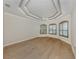 Main bedroom with tray ceiling, plantation shutters, and wood floors at 333 Sunrise Dr, Nokomis, FL 34275