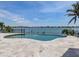 Inviting in-ground pool overlooking the waterfront with lush landscaping and a stone patio at 333 Sunrise Dr, Nokomis, FL 34275