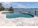 Inviting in-ground pool overlooking the waterfront with lush landscaping and a stone patio at 333 Sunrise Dr, Nokomis, FL 34275