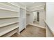 Walk-in closet with custom shelving, drawers, mirror, hardwood floors, and tray ceiling at 333 Sunrise Dr, Nokomis, FL 34275
