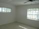 Well-lit bedroom with neutral walls, tiled floor, and two windows for natural light at 334 Dante Dr # 334, Nokomis, FL 34275