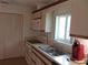 Functional kitchen with white appliances, tiled countertops, and plenty of cabinet storage space at 334 Dante Dr # 334, Nokomis, FL 34275