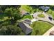 A home on a green cul-de-sac featuring manicured lawns, mature trees, and a paved driveway at 3588 Erie Ct, North Port, FL 34287