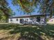 A spacious backyard with lush green grass, sliding glass doors and windows enhance the exterior at 3588 Erie Ct, North Port, FL 34287