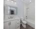Bathroom featuring tiled shower and tub, white vanity, and modern lighting at 3588 Erie Ct, North Port, FL 34287