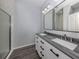 Bathroom with dual vanity, gray counters, and a glass door shower at 3588 Erie Ct, North Port, FL 34287