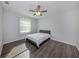 Bedroom with gray wood flooring, ceiling fan, and a window to provide natural light at 3588 Erie Ct, North Port, FL 34287