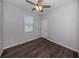This bedroom features gray wood flooring, a ceiling fan, and natural lighting at 3588 Erie Ct, North Port, FL 34287