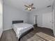 This bedroom is features gray wood flooring, ceiling fan, and multiple doors at 3588 Erie Ct, North Port, FL 34287