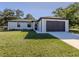 Beautiful single-Gathering home with two-car garage and well-kept lawn on a sunny day at 3588 Erie Ct, North Port, FL 34287