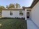Inviting front entrance featuring a decorative door, manicured landscaping, and freshly cut grass at 3588 Erie Ct, North Port, FL 34287