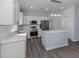 Modern kitchen with stainless steel appliances, white cabinets, and a center island at 3588 Erie Ct, North Port, FL 34287