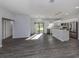 Open-concept living space with gray wood floors, a sliding glass door, and a modern kitchen with stainless appliances at 3588 Erie Ct, North Port, FL 34287