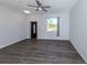 Living room with modern gray flooring, ceiling fan, and an ornate front door at 3588 Erie Ct, North Port, FL 34287
