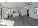 Open-concept living room featuring gray floors, leading to a modern kitchen with white cabinets at 3588 Erie Ct, North Port, FL 34287