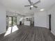 Spacious open-concept living area with modern kitchen featuring stainless appliances, a ceiling fan, and sliding glass doors at 3588 Erie Ct, North Port, FL 34287