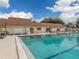 Community pool with lounge chairs, umbrellas, and the clubhouse, perfect for recreation at 3588 Erie Ct, North Port, FL 34287