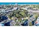 An aerial captures a picturesque community with verdant parks, circular streets and surrounding buildings under blue skies at 3616 Lalani Blvd, Sarasota, FL 34232