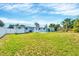 Expansive green backyard featuring a well-kept lawn, a white fence, and the rear exterior of the house under a clear blue sky at 3616 Lalani Blvd, Sarasota, FL 34232