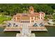 Stunning waterfront estate with a tile roof, a central tower, arched windows and lush landscaping at 3616 Lalani Blvd, Sarasota, FL 34232