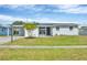 Charming single-story home featuring a well-manicured lawn and updated landscaping, complemented by a mature palm tree at 3616 Lalani Blvd, Sarasota, FL 34232