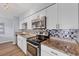 Updated kitchen features sleek stainless steel appliances, granite countertops, and stylish backsplash for a modern aesthetic at 3616 Lalani Blvd, Sarasota, FL 34232