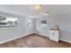 Bright laundry room featuring wood flooring, utility sink with white cabinet, two windows, and a door to the backyard at 3616 Lalani Blvd, Sarasota, FL 34232