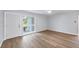 Bright, open-concept living area featuring hardwood floors, a modern ceiling fan, and a sunlit window with front yard views at 3616 Lalani Blvd, Sarasota, FL 34232