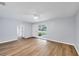 Spacious living room with wood flooring, a modern ceiling fan, and ample natural light streaming through the front window at 3616 Lalani Blvd, Sarasota, FL 34232
