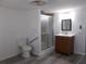Bathroom featuring a toilet, shower, and a sink with a wood vanity and modern mirror at 373 Longwood Dr, Venice, FL 34285