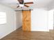 Bright bedroom with a rustic sliding barn door and wood laminate flooring at 373 Longwood Dr, Venice, FL 34285
