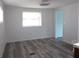 This bedroom has grey wood-look flooring, a fan, and a bright window for natural light at 373 Longwood Dr, Venice, FL 34285