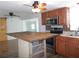 Modern kitchen featuring wood cabinets, stainless steel appliances, and stylish island counter at 373 Longwood Dr, Venice, FL 34285