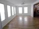 Large living room with laminate floors and lots of bright natural light streaming through three windows at 373 Longwood Dr, Venice, FL 34285