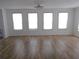 Large living room with laminate floors and lots of bright natural light streaming through four windows at 373 Longwood Dr, Venice, FL 34285