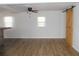 Spacious living room with wood laminate floors, lots of natural light, and a barn door feature at 373 Longwood Dr, Venice, FL 34285