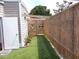 Private outdoor shower area with artificial turf and decorative bamboo fencing, perfect for rinsing off after a swim at 373 Longwood Dr, Venice, FL 34285