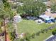 Aerial view of backyard shows the deck, patio, shed, yard, hot tub and mature shade tree at 413 Valencia Rd, Venice, FL 34285