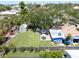 Aerial view of a lush backyard featuring a large shade tree, a storage shed, and outdoor seating at 413 Valencia Rd, Venice, FL 34285