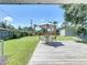 A relaxing backyard featuring a wooden deck with a table and chairs, perfect for outdoor dining and entertaining at 413 Valencia Rd, Venice, FL 34285