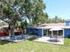 Large backyard with grass, deck and patio with table, chairs, and hot tub with mature shade tree at 413 Valencia Rd, Venice, FL 34285