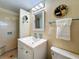 Bathroom with light-colored tile, white vanity with sink, shower and toilet at 413 Valencia Rd, Venice, FL 34285