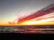 Vibrant sunset over the ocean, reflecting off the wet sand, with silhouettes of people on the beach at 413 Valencia Rd, Venice, FL 34285