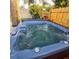 Inviting backyard hot tub with privacy fence, set on a wooden deck for relaxation at 413 Valencia Rd, Venice, FL 34285
