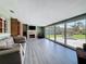 Living room with a gray couch, fireplace, TV and large glass doors leading to a wood deck and backyard at 413 Valencia Rd, Venice, FL 34285