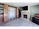 Living room featuring light wood floors, built-in cabinets, fireplace with TV, and a hideaway fold-out table at 413 Valencia Rd, Venice, FL 34285